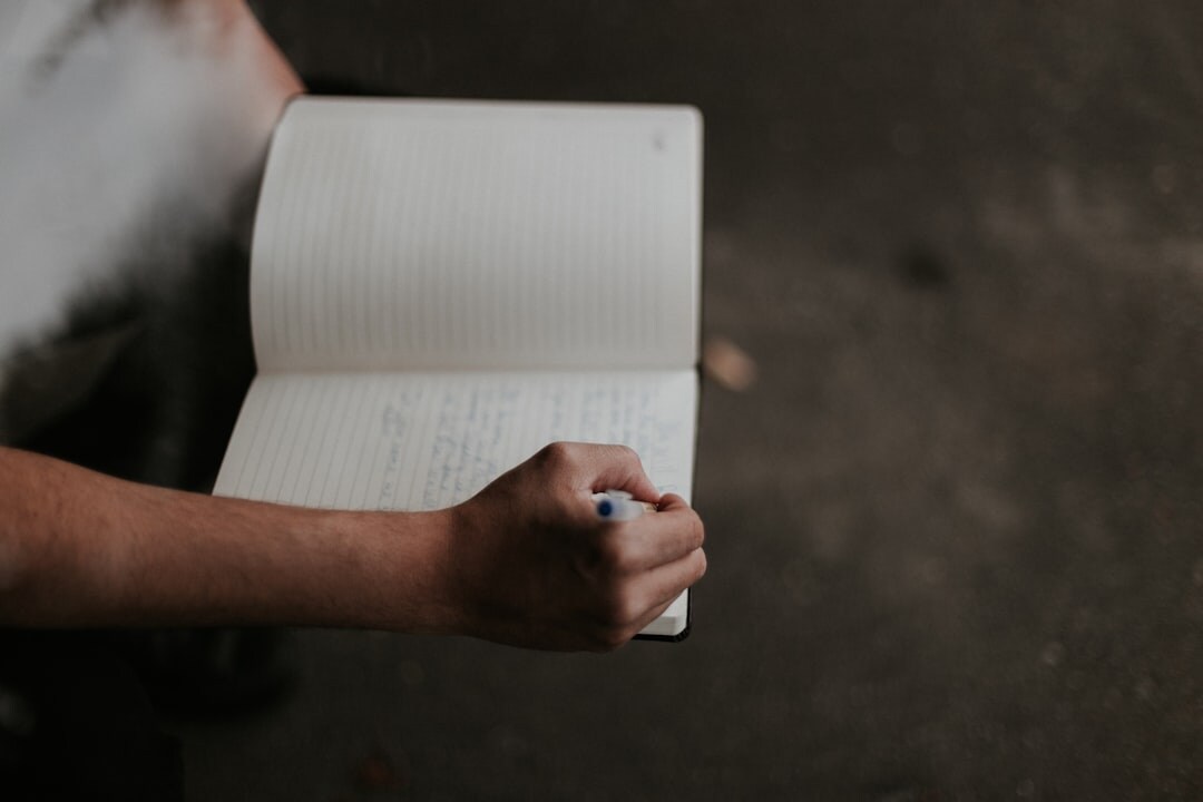 person writing in journal outdoors