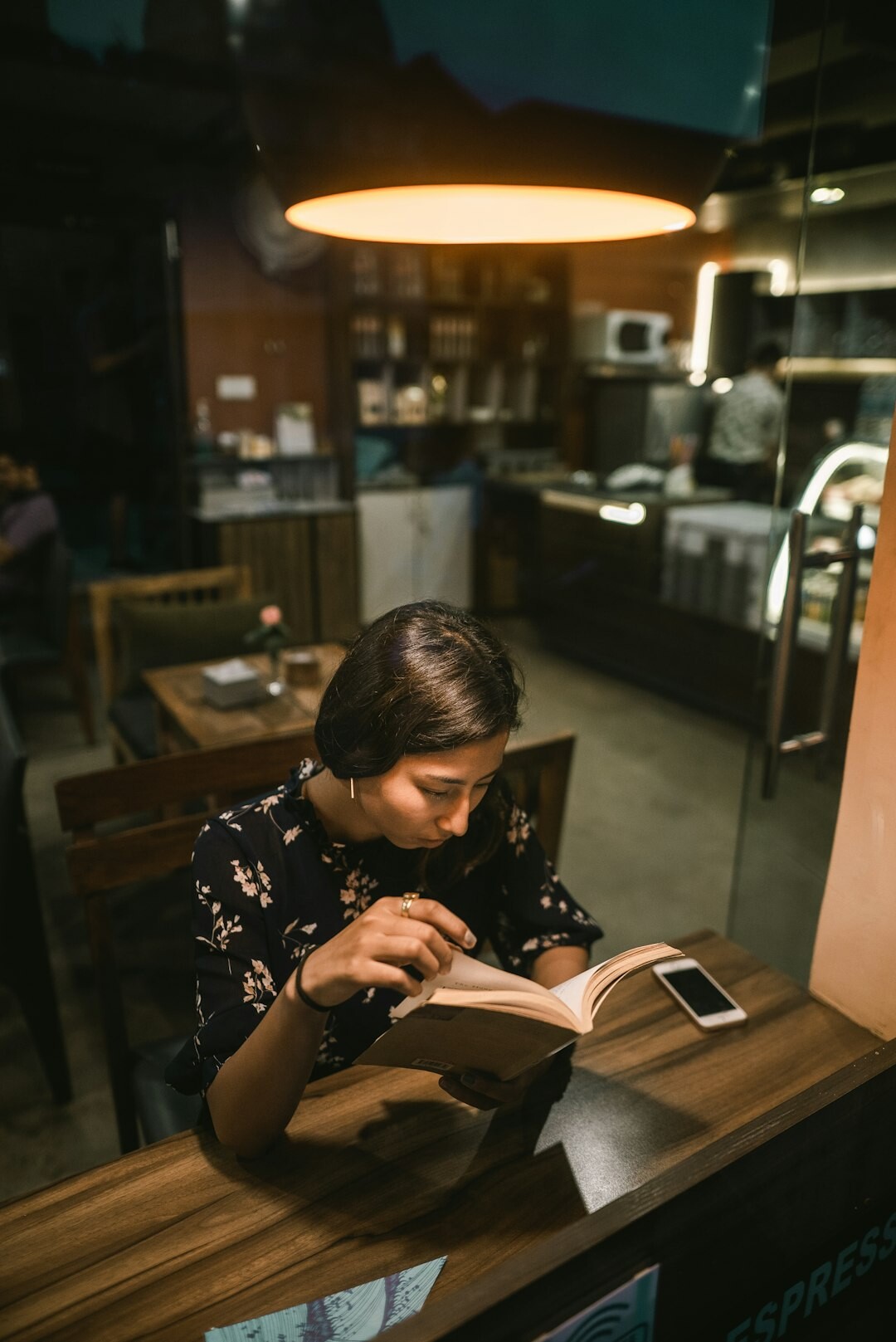 Mulher brasileira lendo e fazendo anotações em uma mesa de madeira
